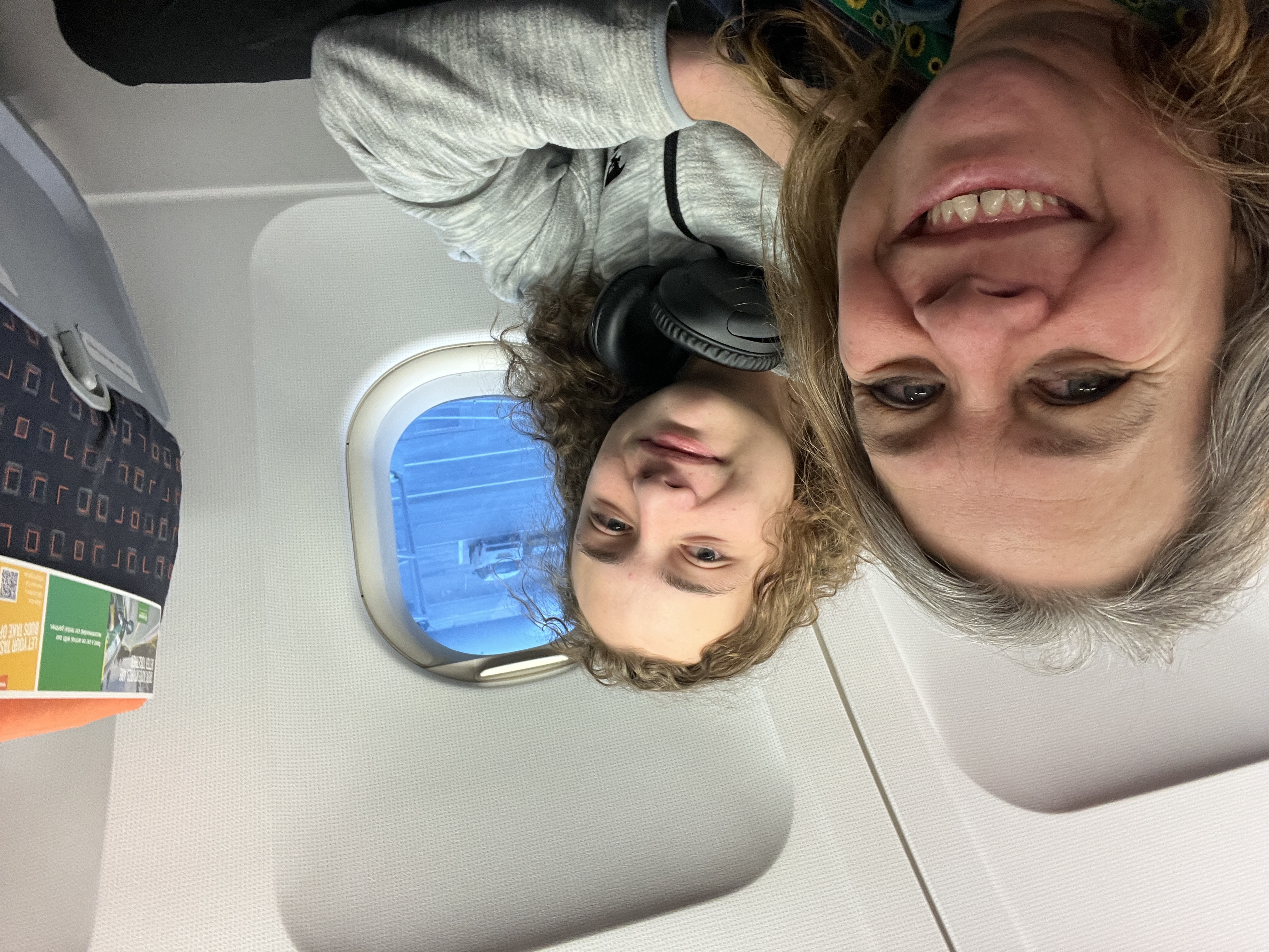 The author (in the aisle seat) and her son (in the window seat) in an airplane that is at the gate waiting to depart